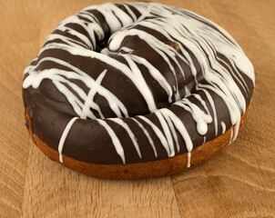 bun covered with chocolate, on a wooden board