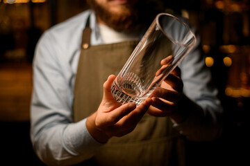 close-up of male hands holding a clean transparent empty cocktail glass