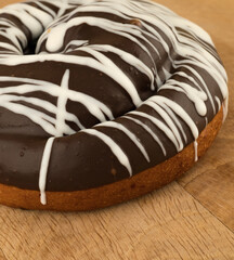 bun covered with chocolate, on a wooden board
