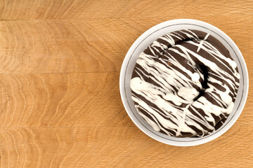 bun covered with chocolate, on a wooden board