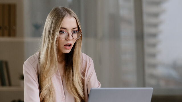 Scocked caucasian millennial business woman female student worker user receiving bad news message low grade test failed exams losing computer bet feeling shock lost fear horror looking at laptop