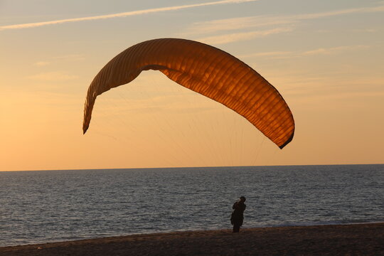 Paragliding with sunset reverse light, parachute with amazing sky