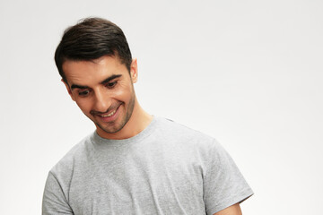 Fototapeta premium Cheerful man in gray t-shirts posing lifestyle casual wear isolated background