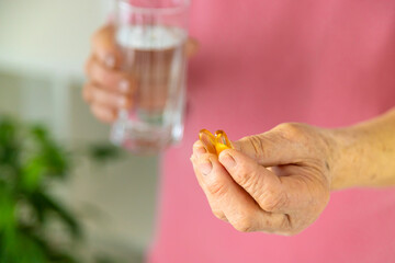 Omega 3 old woman drinks. Selective focus.