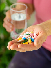 An old woman holds pills in her hands. Selective focus.