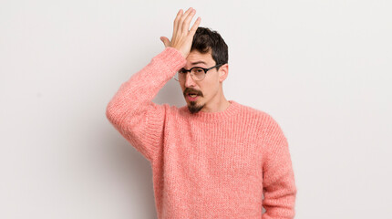 hispanic young man raising palm to forehead thinking oops, after making a stupid mistake or...