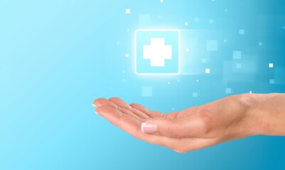 Person's hand holding plus icon on the background. Profit,health insurance, growth concepts.