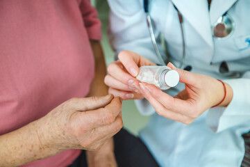 The doctor gives pills to an old woman. Selective focus.