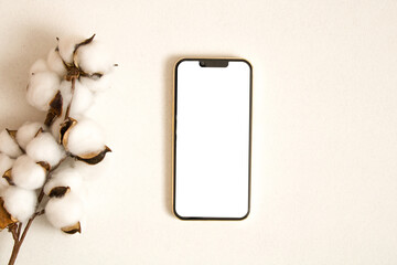 Mobile phone mockup with cotton leaves on the white background
