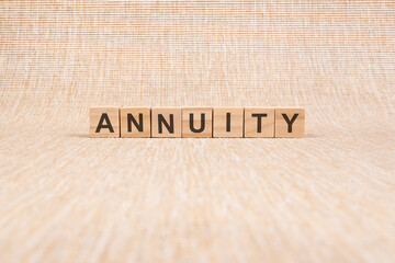 ANNUITY word written In wooden cube on brown background