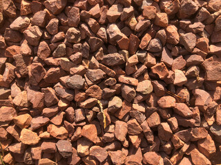 A red coloured gravel, stone chippings making up a path