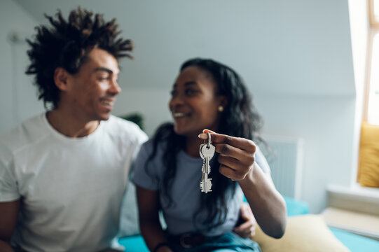 African american couple holding home keys in their new apartment