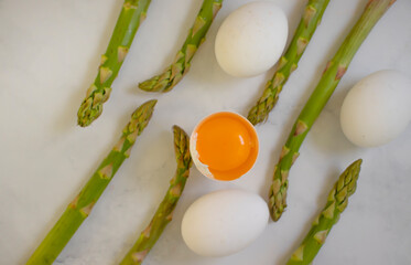 asparagus, raw egg on old background