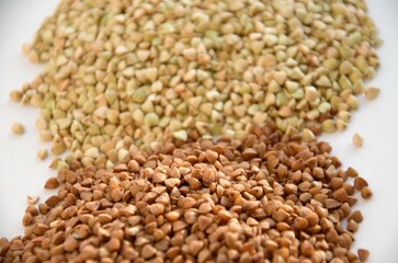 cereals of buckwheat and green unboiled buckwheat on a white background