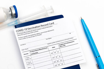 Covid-19 vaccine vial, vaccination record card, syringe, a pen  Coronavirus vaccination concept. - Image
