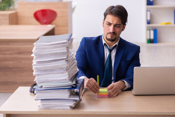 Young male employee and too much work in the office