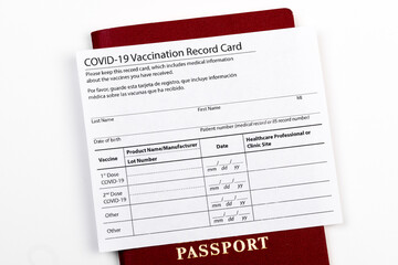 Coronavirus vaccination record card, biometric passport and blue medical mask on light gray desk. Concept of defeating Covid-19. Vaccination as prerequisite for travel - Image