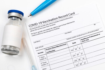 Covid-19 vaccine vial, vaccination record card, syringe, a pen  Coronavirus vaccination concept. - Image