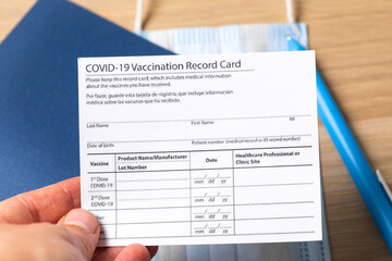 Fototapeta na wymiar COVID-19 vaccination record card and tourist passport for worldwide travel during coronavirus pandemic. - Image