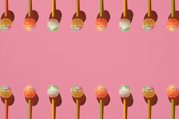 Colorful Set of Lollipops. pattern made with caramel on a stick on bright pink background.  creative pattern.