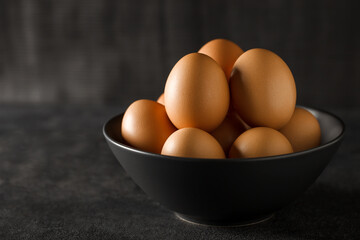 Eggs whole chicken, many stacked in a bowl, selective focus.