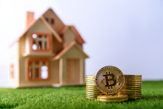 Pile of bitcoin coins in front of house