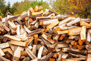 Stock of firewood for heating the house. The trees were cut down and split into firewood to be used as heating fuel in fireplaces and stoves, firewood background.