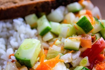 Rice with vegetables and a slice of bread. Dinner plate. Vegetarian lunch. Rice with salad in a bowl.