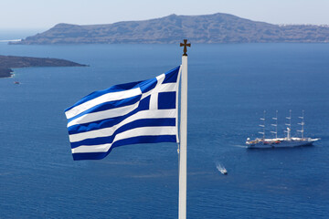 Greek flag waving against the blue sky.