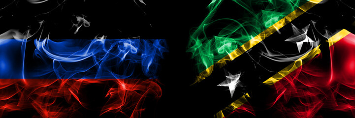Donetsk People's Republic vs Saint Kitts and Nevis flag. Smoke flags placed side by side isolated on black background.