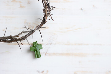 Partial crown of thorns and small Christian cross made of palm leaf