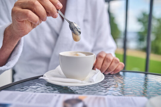 Close up picture of a person having coffee and the balcony