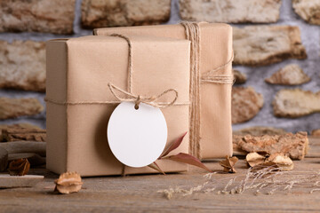 Round white gift tag mockup on Christmas or Valentines Day wrapped presents on rustic wooden...