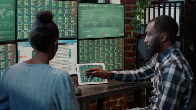 Business partners brainstorming ideas to develop stock market growth, looking at tablet and multi monitors to see investment exchange numbers changing. Forex tranding money sales.