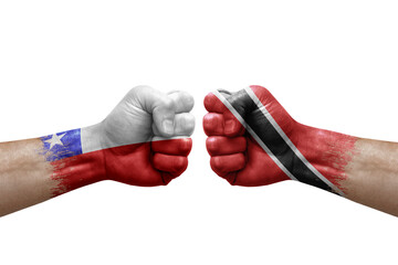 Fototapeta premium Two hands punch to each others on white background. Country flags painted fists, conflict crisis concept between chile and tobago