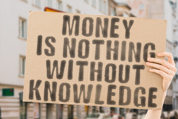 The phrase " Money is nothing without knowledge " on a banner in men's hand with blurred background. Grow. Office. Work. Earn. Pay. Pile. Stock. Save. Rich. Plan. Loan. Fund. Coin. Idea. Cash