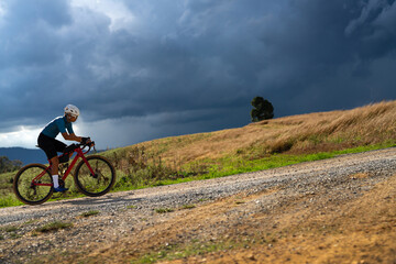 Fototapeta na wymiar Cyclists practicing on gravel roads in bad weather day