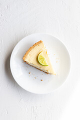 Slice of Lime Cheesecake on a White Plate and White Background