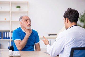 Fototapeta premium Old male patient visiting young male doctor