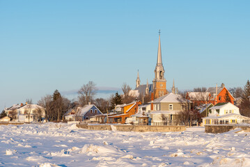 Naklejka premium In winter, at the sunset, the town of Kamouraska see from the pier in the harbor (Bas-Saint-Laurent, Quebec, Canada)