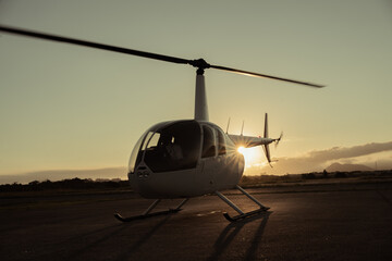 Fototapeta na wymiar Helicopter on the runway at sunset.