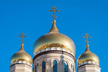The golden domes of the newly built church against the blue sky.