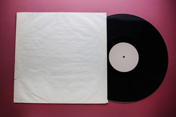 Classic vinyl record with packaging closeup on a red burgundy background, outdated data storage, music