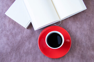 赤いコーヒーカップと本（茶色の背景）