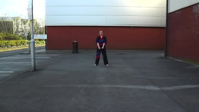 Georgia Debney performing ITF taekwondo pattern Choong Moo outside on a tarmac floor