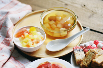Chinese desserts, milk pudding fruit salad and Mix ginkgo nuts cassava syrup coconut jelly in longan juice on glass bowl, Thai and Chinese longan date soup Asian dessert sweets