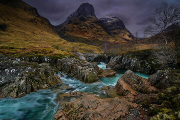 The River Coe Rapids with the backdrop mountain view of the three sisters, Glencoe, Highlands Scotland.
 - obrazy, fototapety, plakaty
