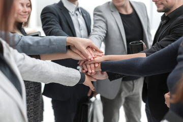 young employees making a stack out of their hands