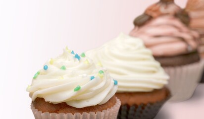 Many different cupcakes with decorations and toppings in a pastry shop concept