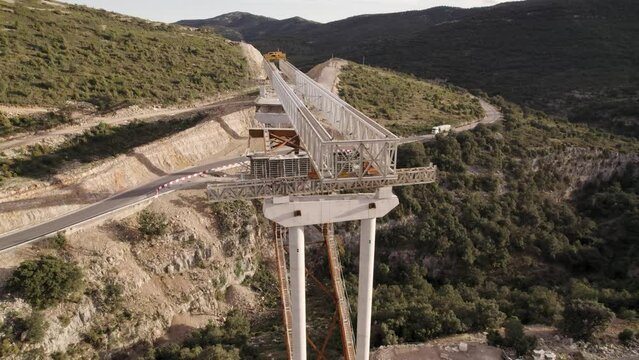Slow drone footage over the loading beams of an unfinished bridge&acute;s structure under construction in Barranco de la Bota in Morella on a sunny afternoon
